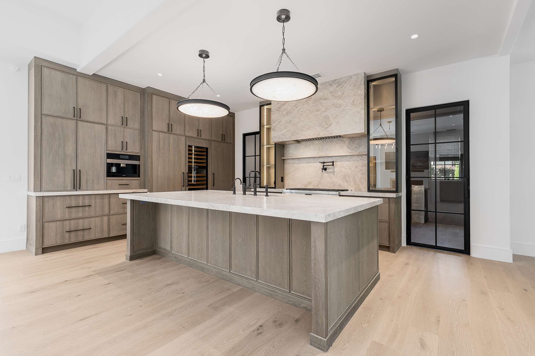 Kitchen island and oak cabinetry in a Brookhaven custom home built by VIBE